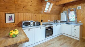 A wooden-paneled kitchen with a microwave, toaster, sink, and oven. - Stunning private villa for 8 guests with WIFI, TV, terrace and pets allowed (Cannich)