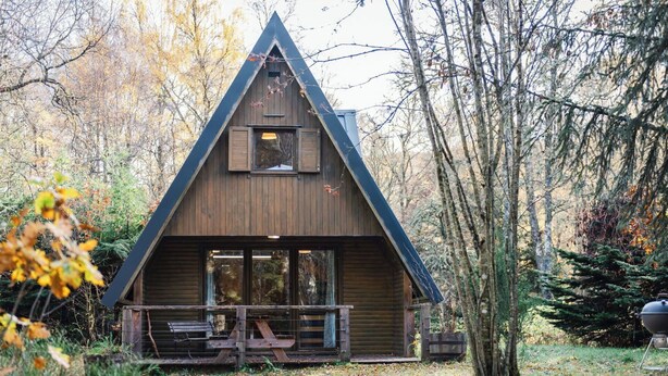 A cabin with a triangular roof, large windows, and a wooden deck. - Stunning private villa for 8 guests with WIFI, TV, terrace and pets allowed (Cannich)