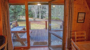 A wooden cabin with a fire exit sign, a wooden deck with picnic tables, and a view of the forest. - Stunning private villa for 8 guests with WIFI, TV, terrace and pets allowed (Cannich)