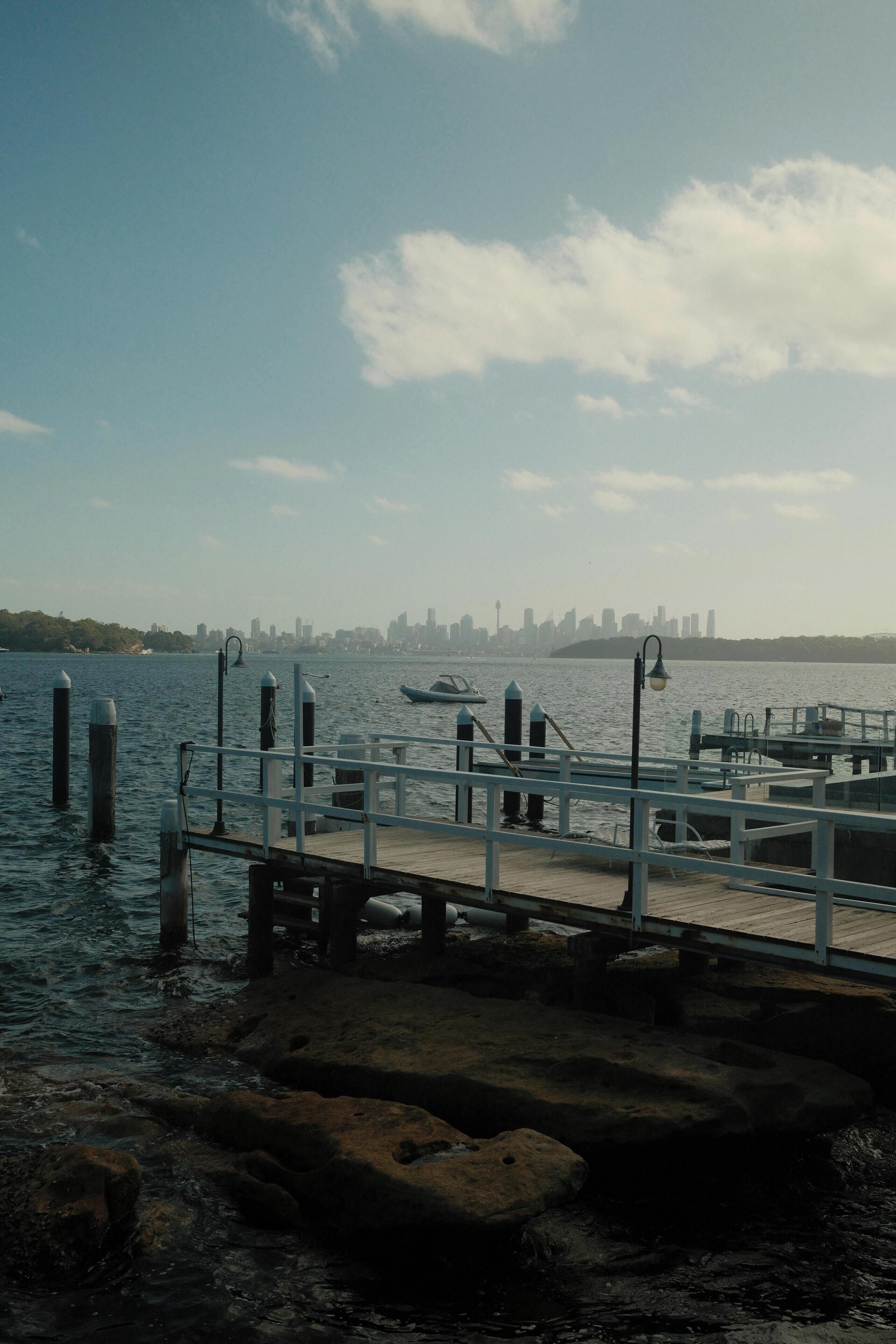 A waterfront dock with a city skyline in the background.