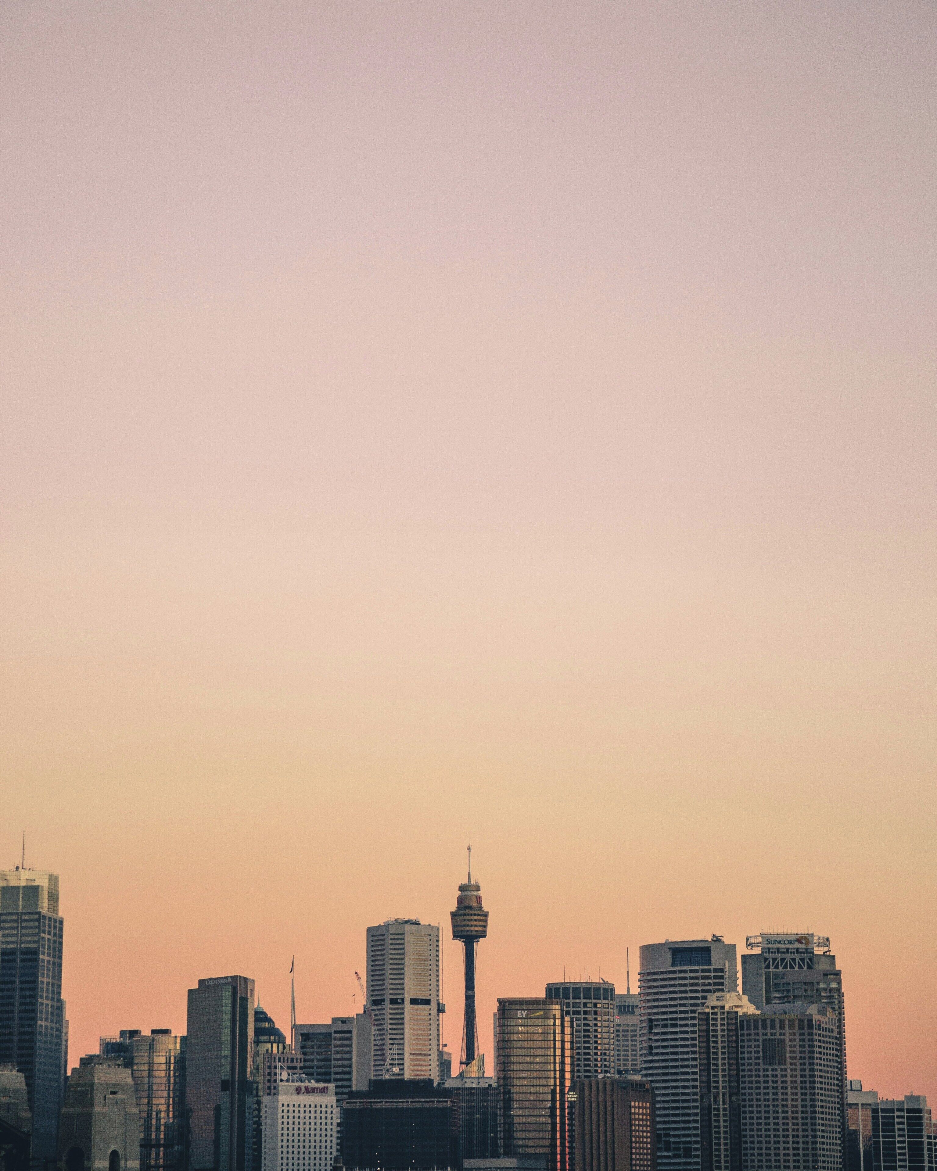 Une vue sur les toits d’une ville, avec des immeubles modernes et des gratte-ciel, dont une tour particulièrement imposante.