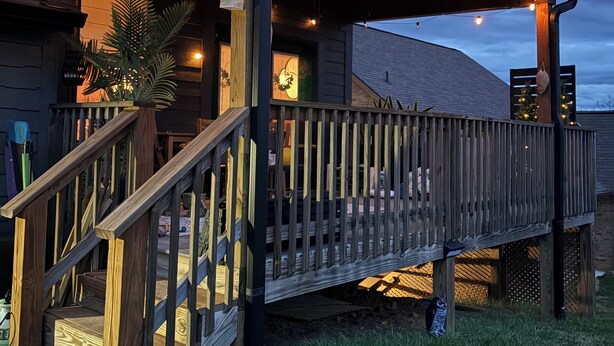 A wooden deck with a railing, a staircase, and string lights. - East TN home with lake views & 2 kitchens (Morristown)