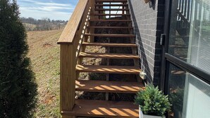 A wooden staircase leading to a building with a black exterior and a large window. - East TN home with lake views & 2 kitchens (Morristown)