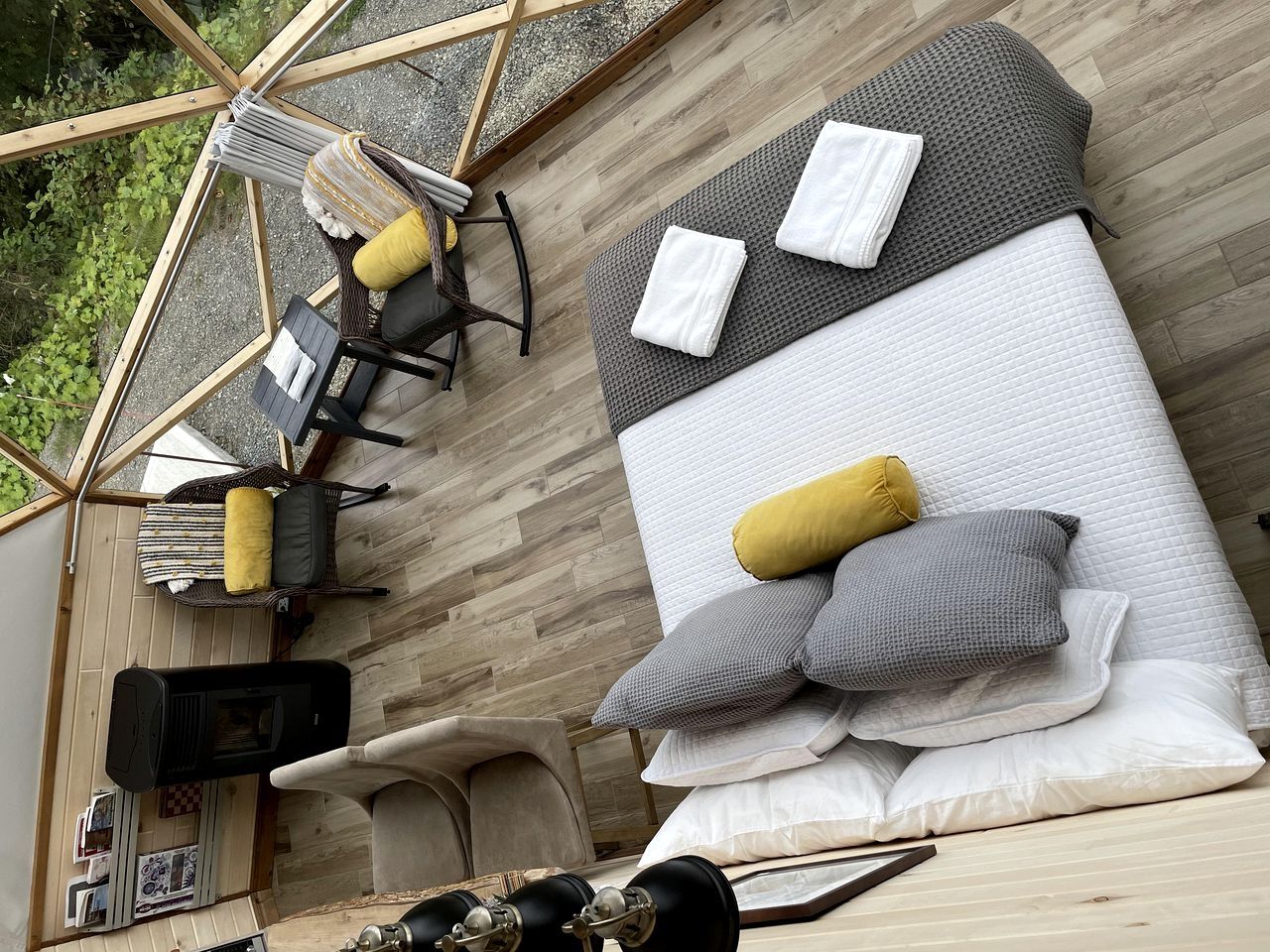 A room with a bed, a sofa, and a chair. There is a small table with a lamp.