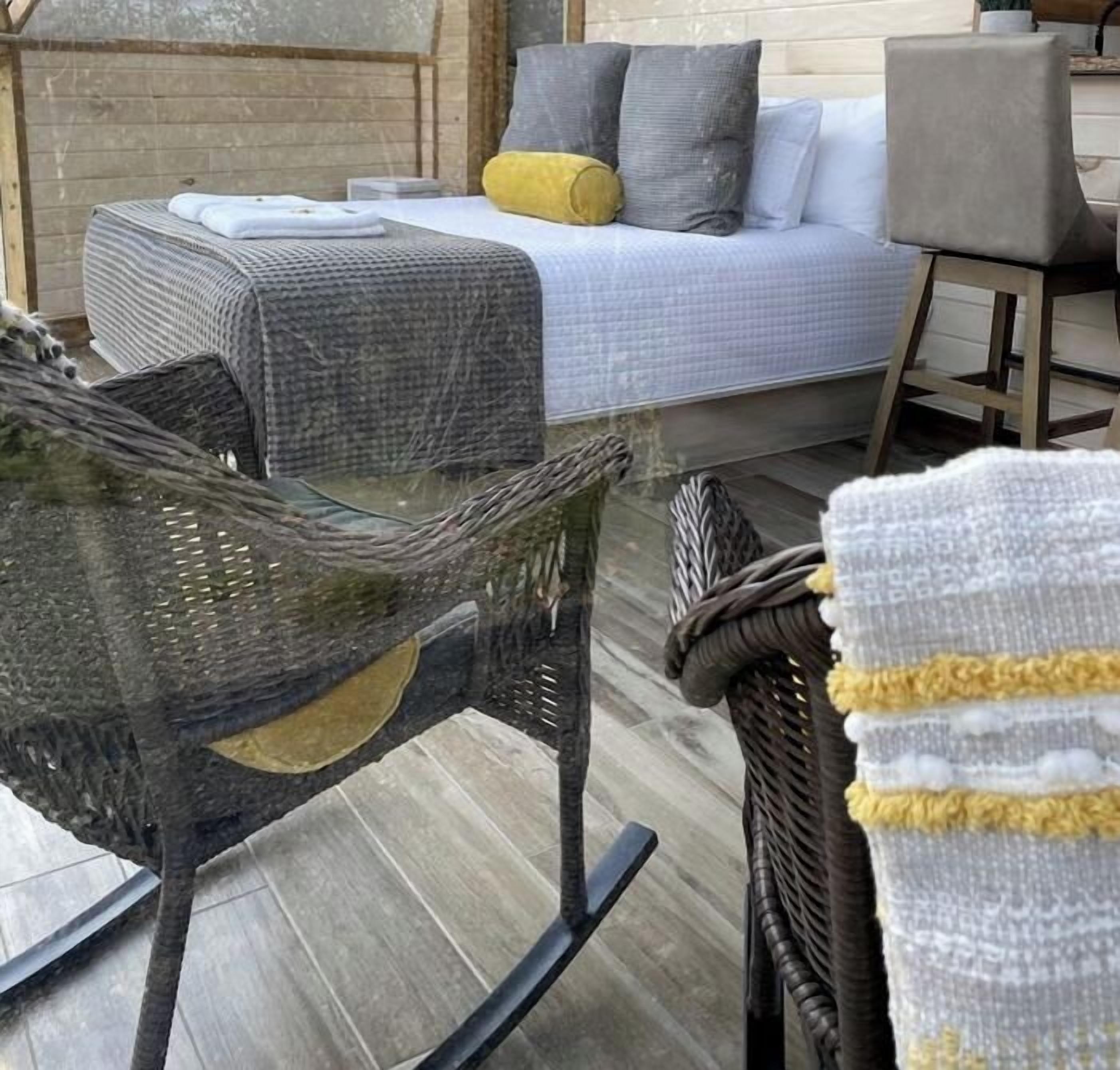 Une pièce comprenant un lit, une chaise et un panier en osier.