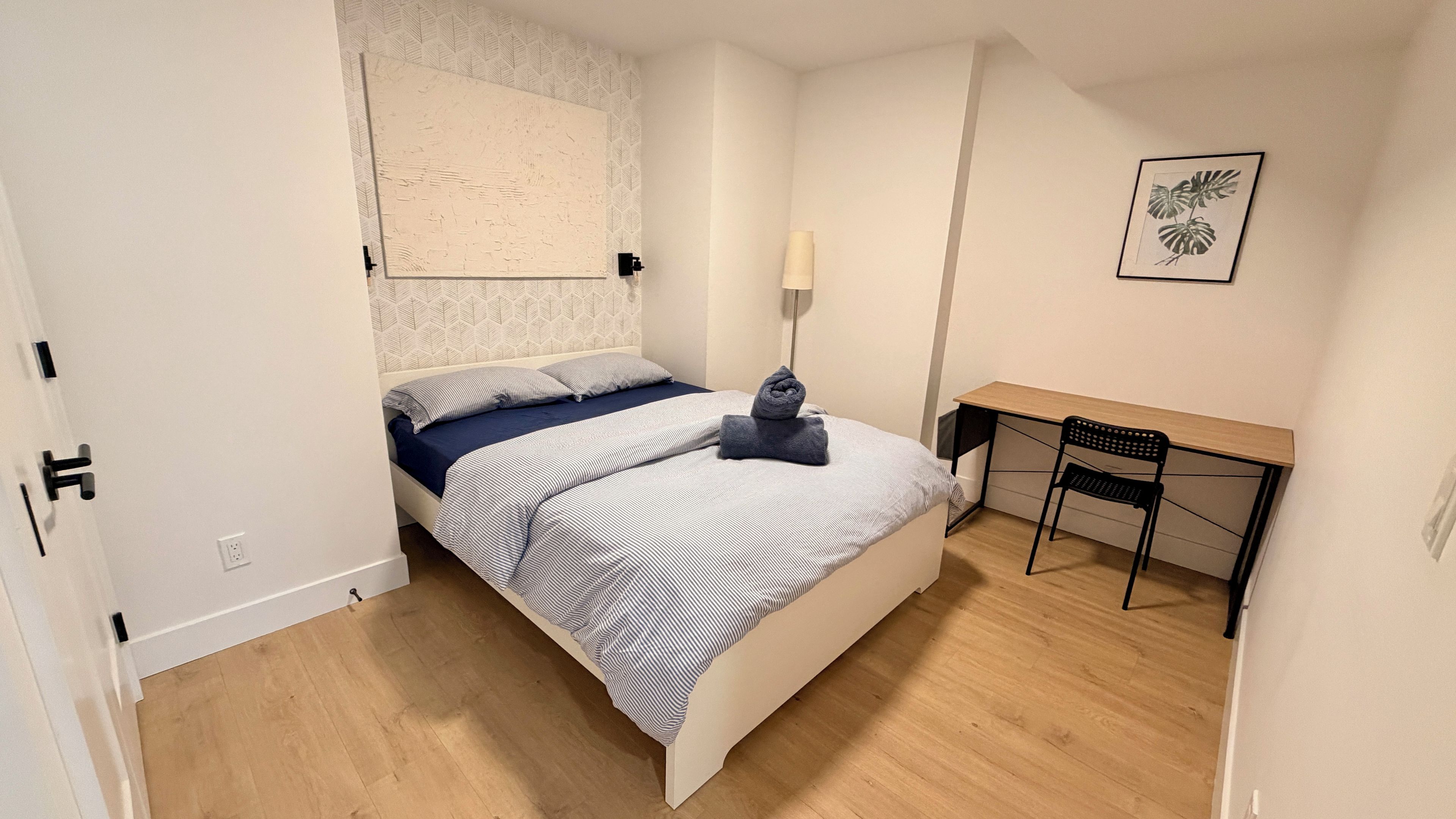Un dormitorio con una cama, un escritorio y una silla.