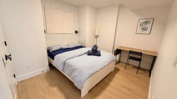 Un dormitorio con una cama, un escritorio y una silla.