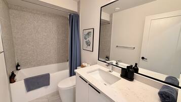 Ein modernes Badezimmer mit Badewanne, Toilette und Waschbecken.