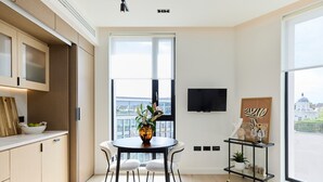 Cozinha moderna com área de refeições, grandes janelas e vista para a cidade.