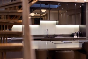 A modern kitchen with a stainless steel sink, a kettle, and a toaster on the countertop. - 10a OG Primrose Hill Townhouse-industrial Chic Design 10 (London)