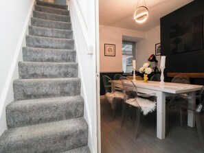A staircase leading to a dining area with a table, chairs, and a chandelier. - 50 Gladstone Avenue (Chester)