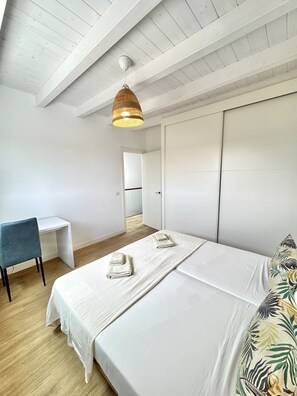 Ein Schlafzimmer mit einem Bett, einem Schreibtisch und einem Stuhl.