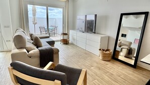 A modern living room with a sofa, armchair, and a large mirror. - Casahost Dolce Vita Villa Eira (Costa Teguise)