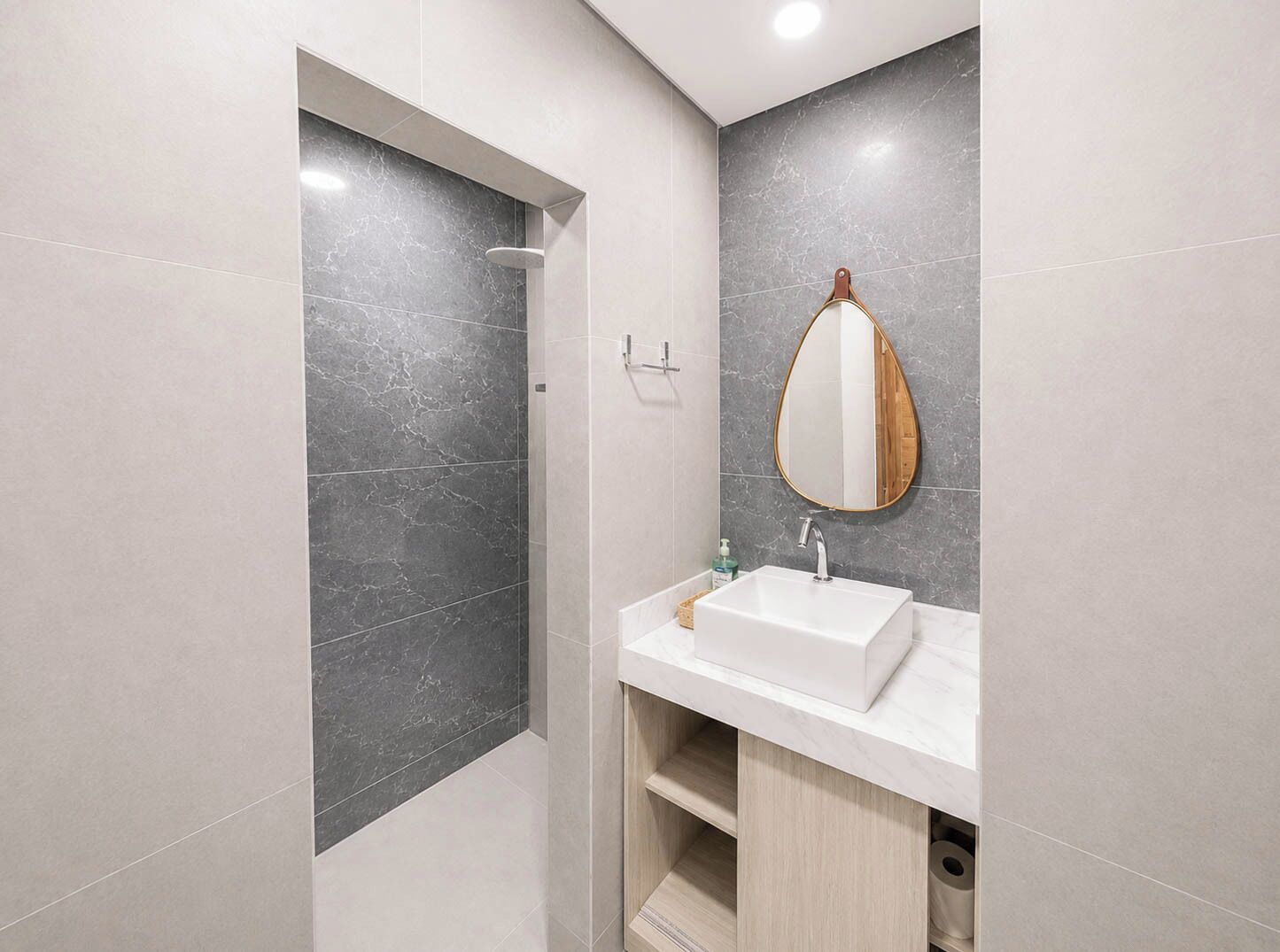 Un baño moderno con ducha, lavabo y espejo.