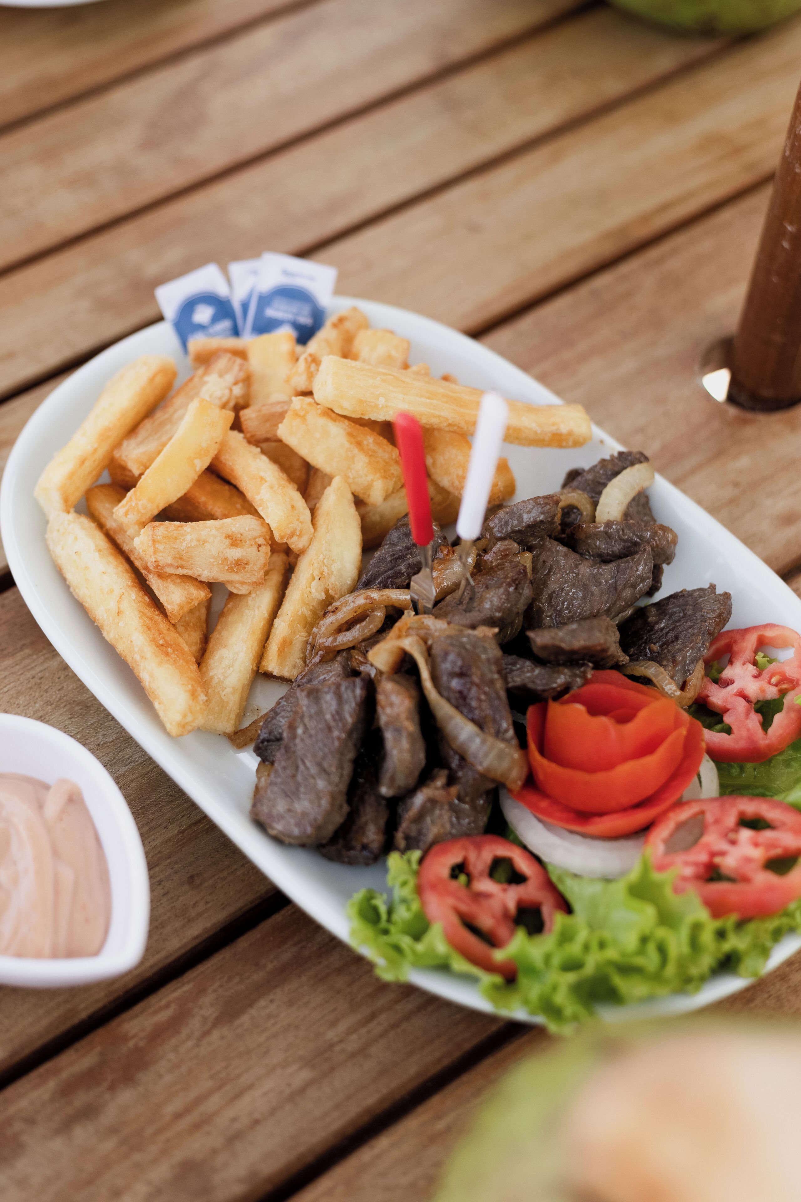 Un plato de comida con papas fritas, carne y verduras.