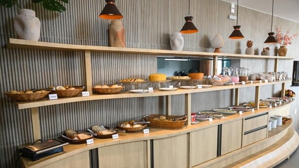 Disposição de buffet com diversos alimentos e cestas identificadas com nomes.