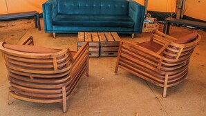 A room with a blue sofa, wooden chairs, a coffee table, and a patterned rug. - Firefly Cottage (Cirencester)