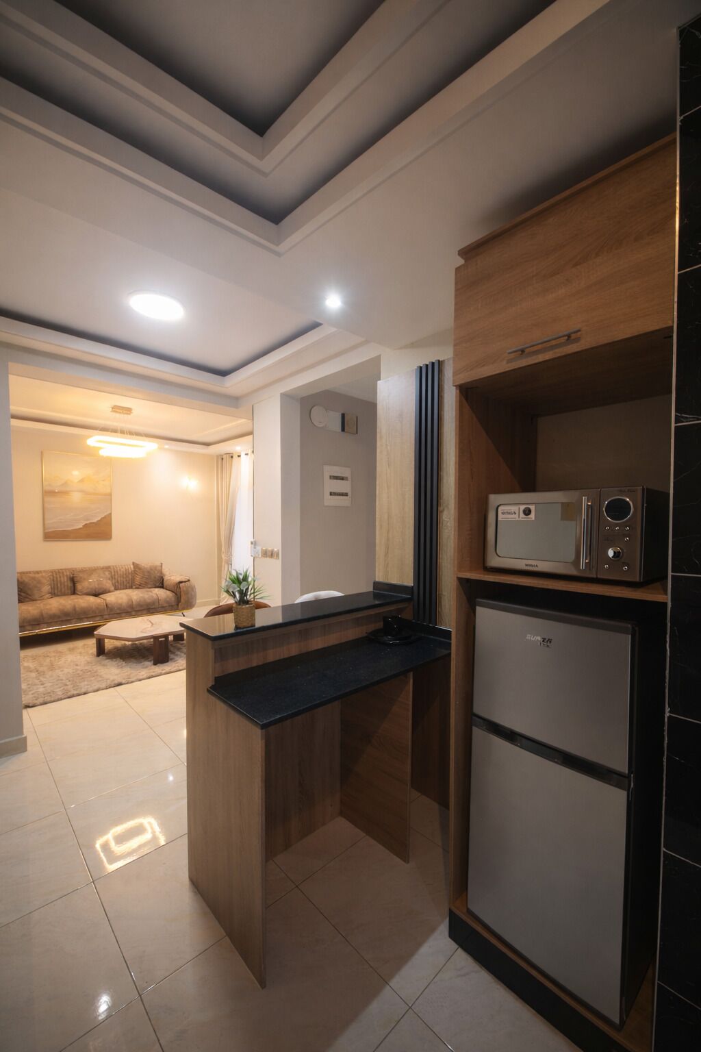 Eine moderne Küche mit Einbau-Mikrowelle, Kühlschrank und einer Holzarbeitsplatte.