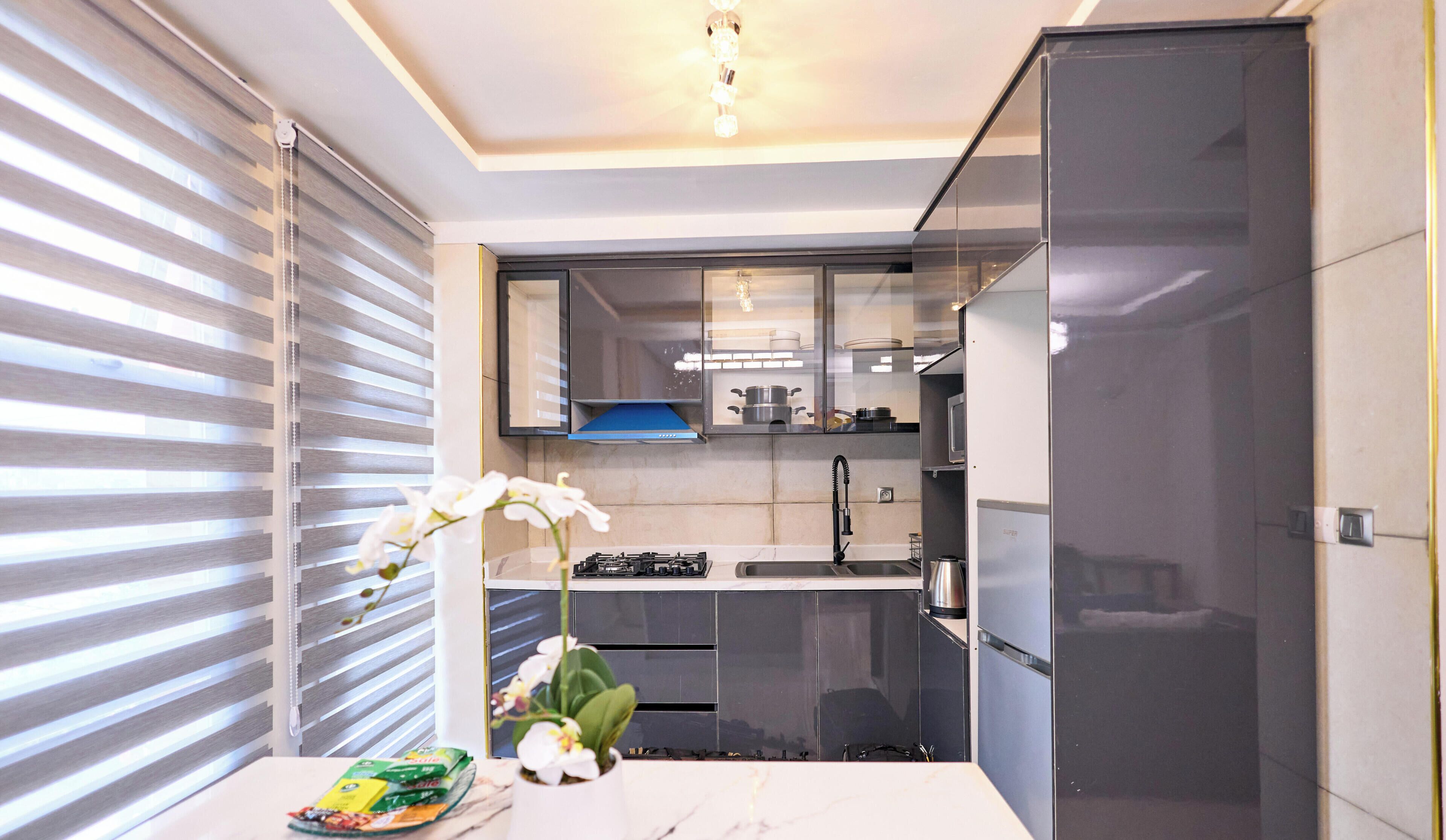 A modern kitchen with a built-in oven, a sink, and a microwave.