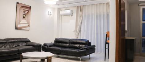 Una sala de estar moderna con un sofá, un sillón y una mesa de centro.