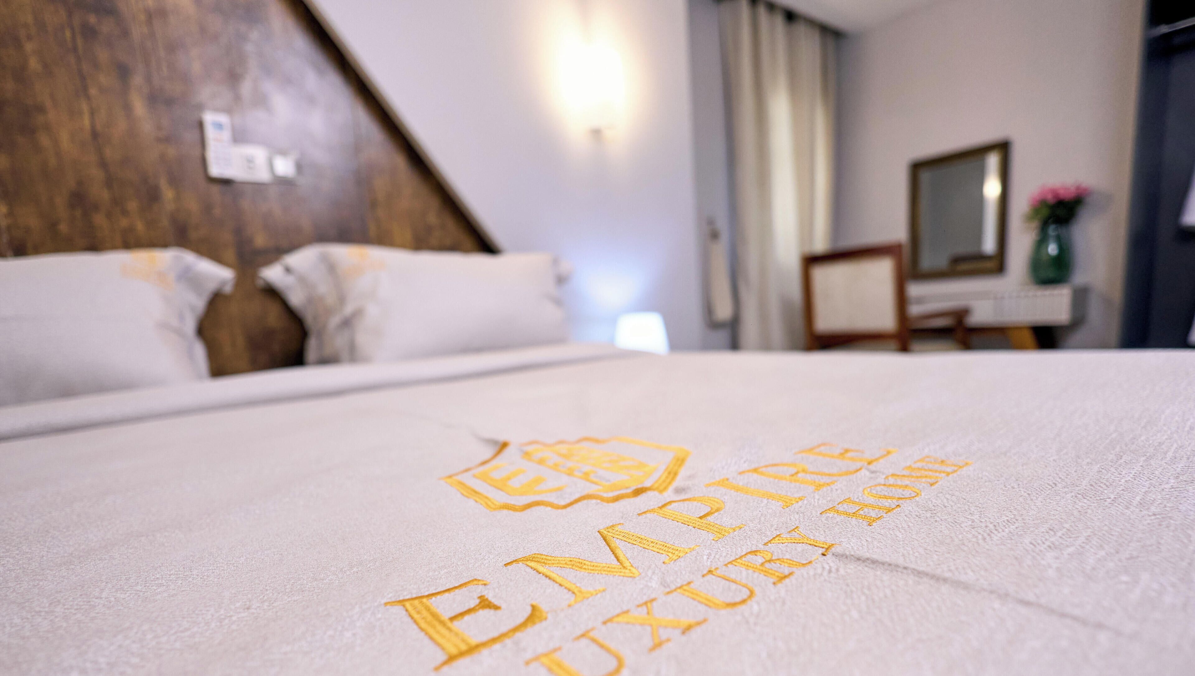 Una cama con una toalla que dice 'EMPIRE LUXURY HOME'.