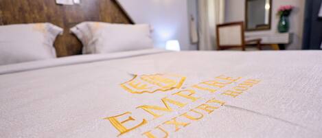 Una cama con una toalla que dice 'EMPIRE LUXURY HOME'.