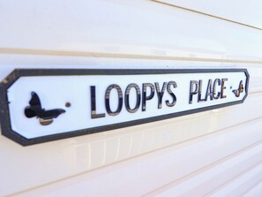 A sign with the text 'LOOPYS PLACE' and a butterfly symbol. - Loopys Place - Pg178 (Skegness)