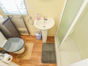 A bathroom with a toilet, sink, and shower. - Loopys Place - Pg178 (Skegness)