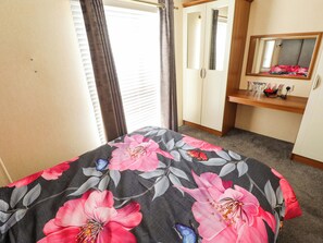A bedroom with a bed, a wardrobe, a mirror, and a desk. - Loopys Place - Pg178 (Skegness)