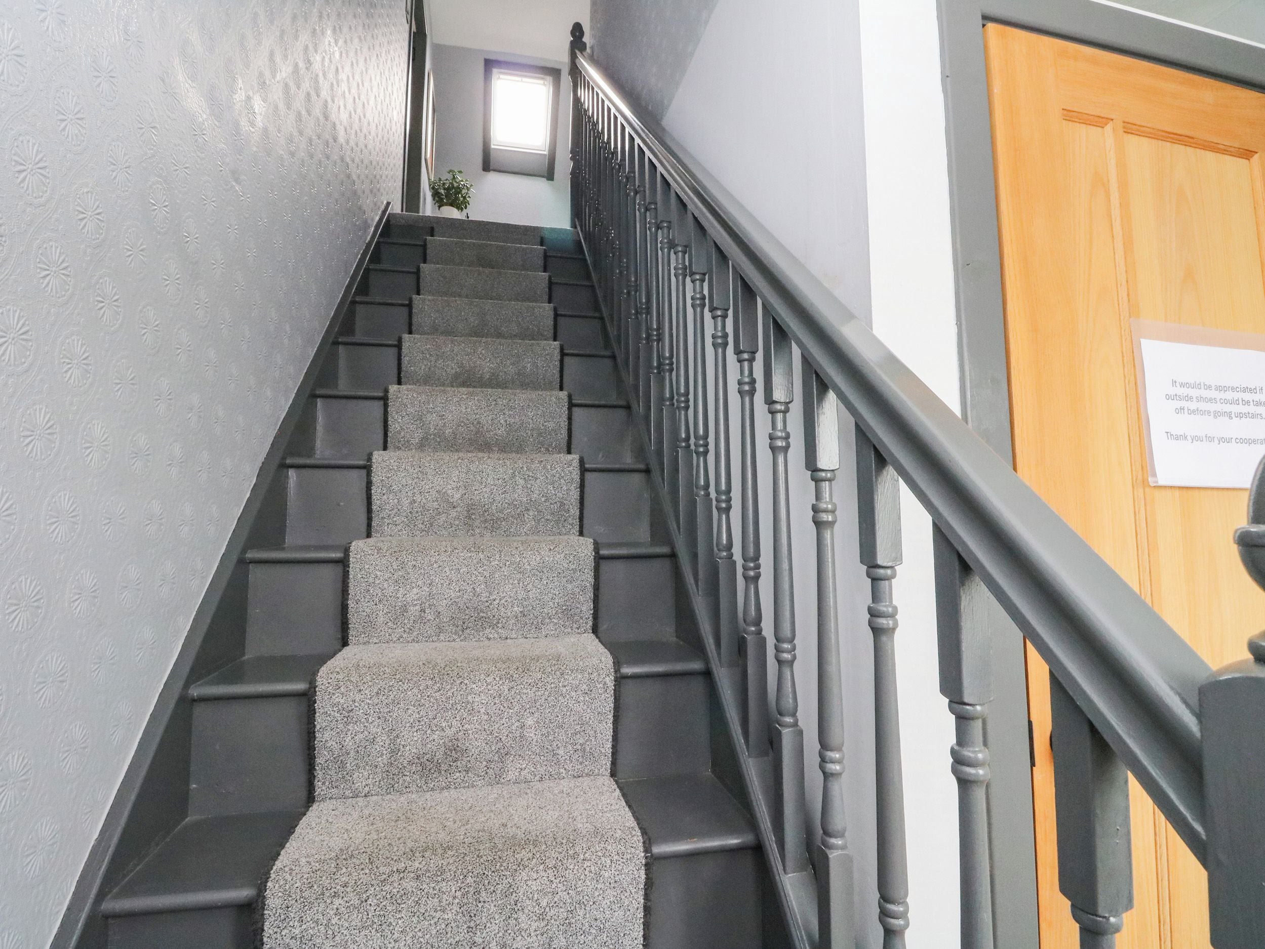 A staircase with carpeted steps and a wooden handrail.
