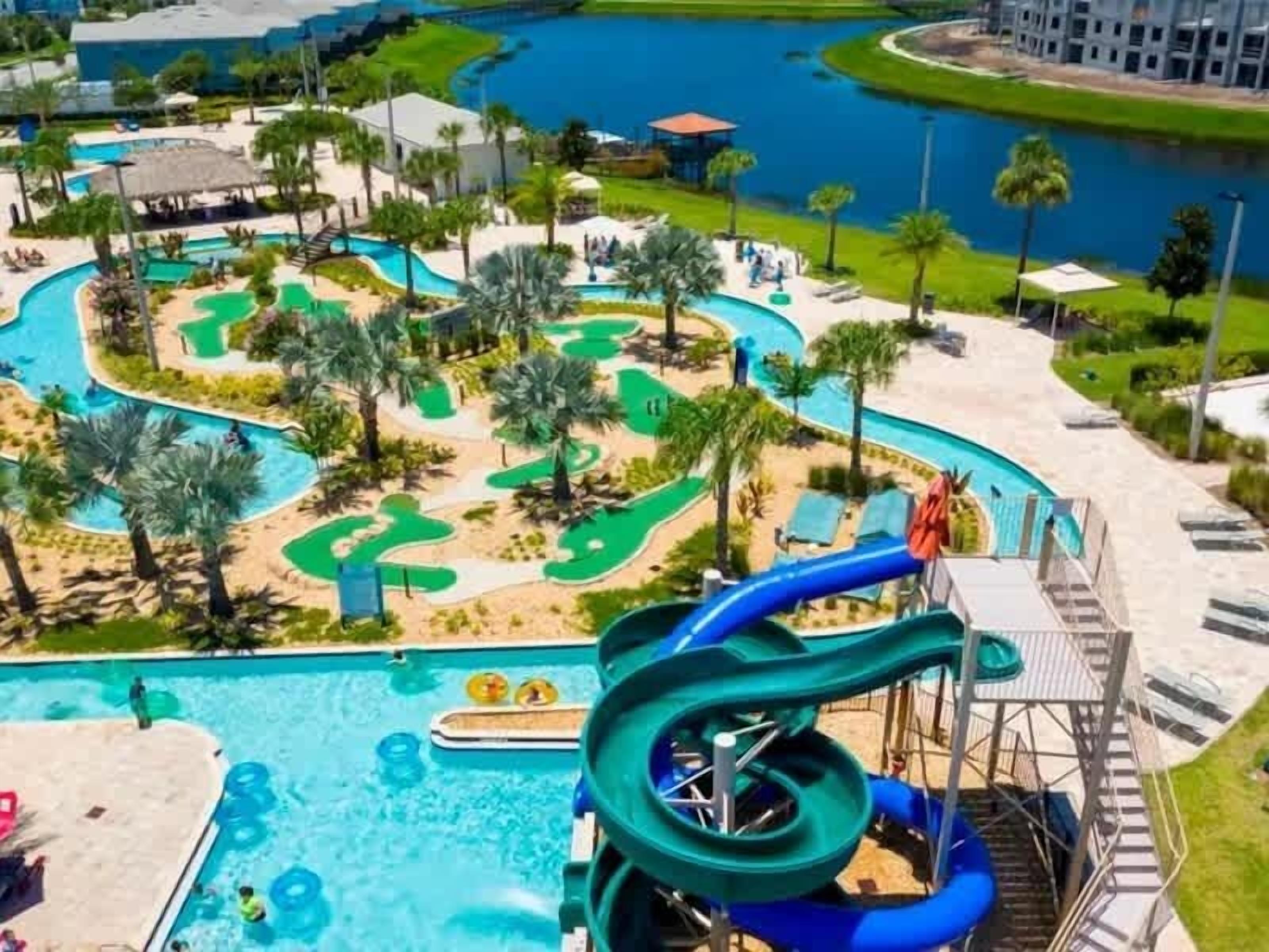 A water park with a large pool, slides, and a golf course.