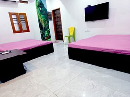 Una habitación con dos camas, televisión, ventana con vistas y puerta.