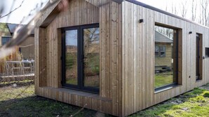 A modern wooden building with large windows and a flat roof. - Tiny House with air conditioning in Oud Ade | Tuin van Keet - 17 (Oud Ade)