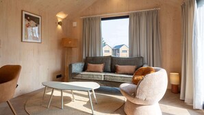 Une pièce confortable avec un canapé, un fauteuil et une petite table.