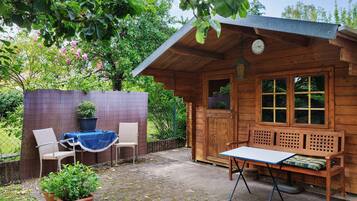Eine Holzhütte mit einer Bank, einem Tisch und zwei Stühlen.