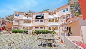 A traditional building with a sign reading 'Townhouse Oak,' featuring a courtyard with stone paving, outdoor seating, and potted plants. - Classic Kumbhal Castle (Kumbhalgarh)