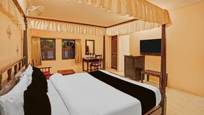 A bedroom with a four-poster bed, a desk, a chair, a television, and a wardrobe. - Classic Kumbhal Castle (Kumbhalgarh)