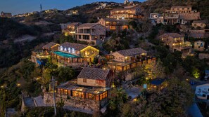 A hillside property with multiple buildings, including a restaurant with outdoor seating and a stone house with a tiled roof. - Aurora Rock Villa Resort (Taizhou)