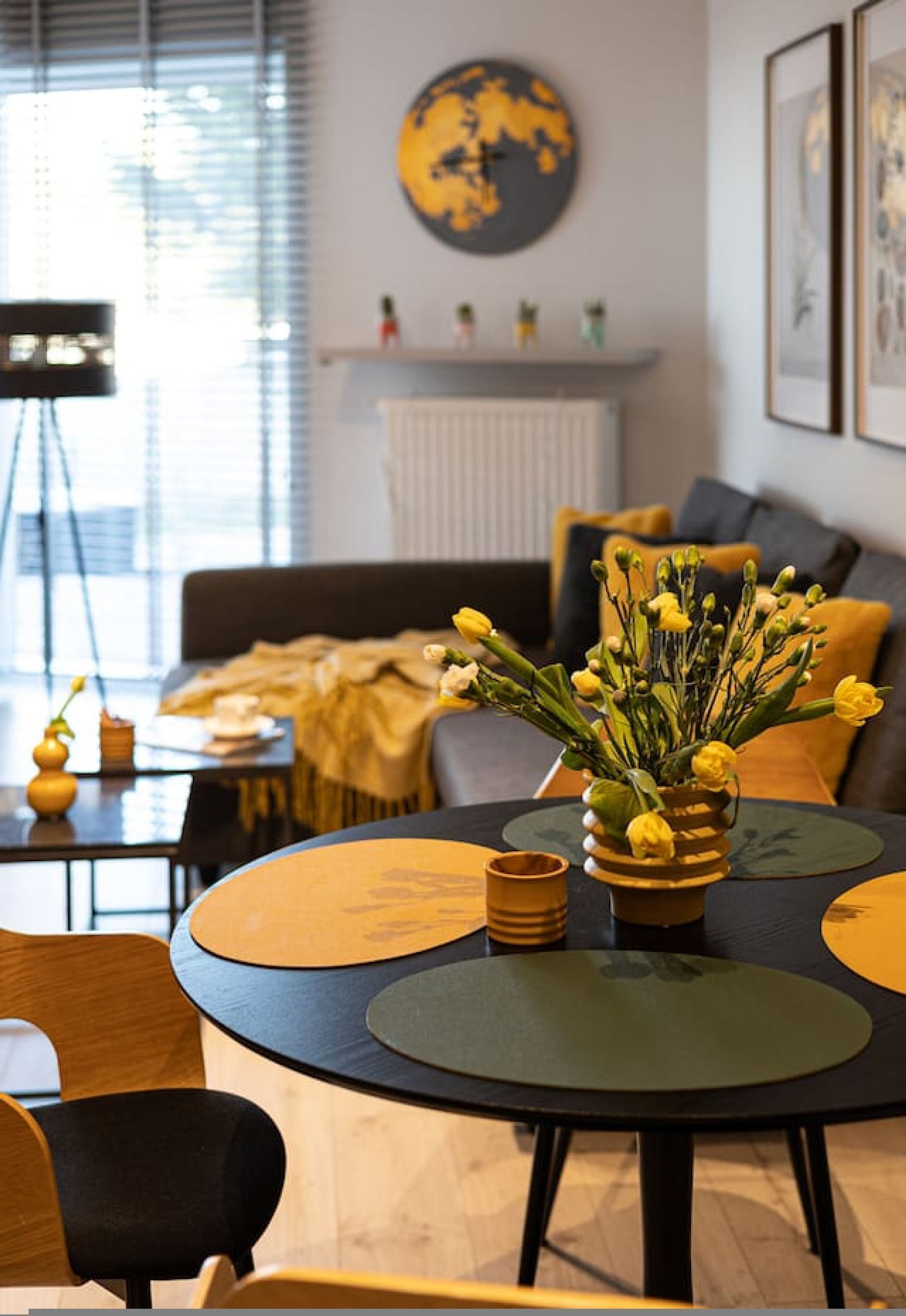 Un salon moderne avec une table ronde, un canapé et un globe terrestre accroché au mur.