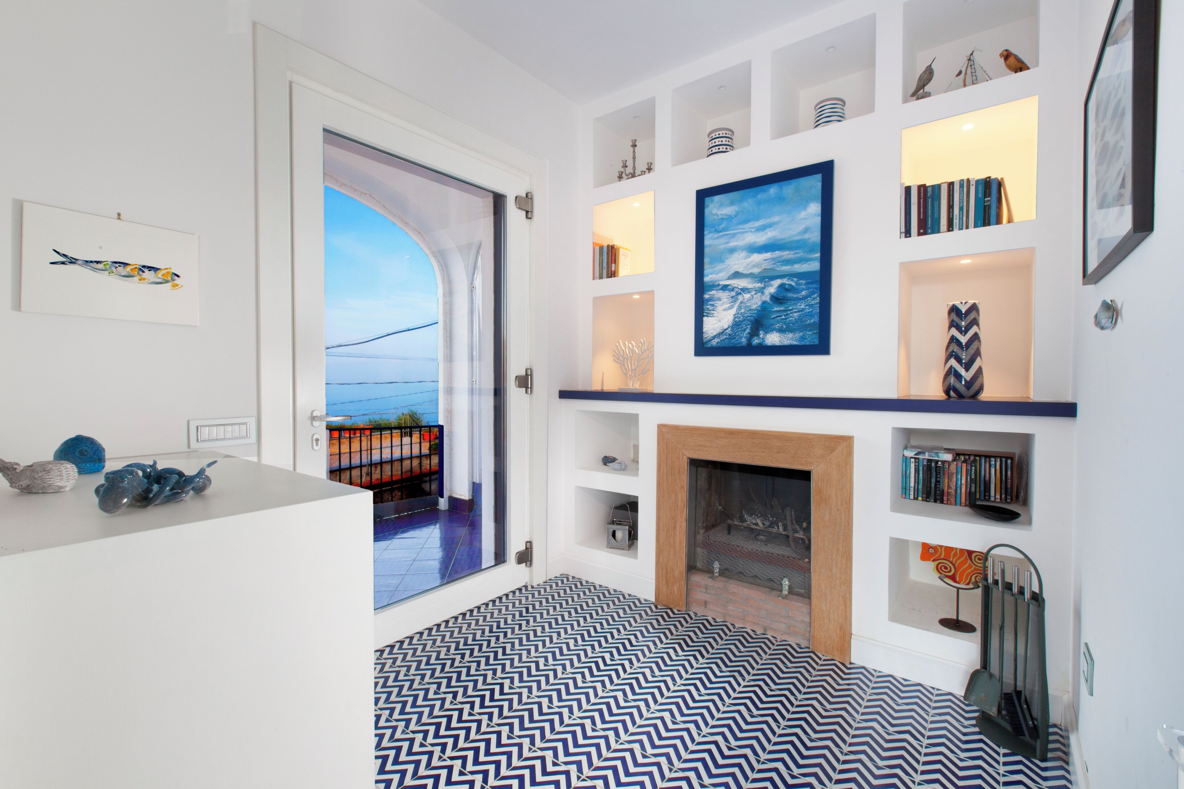 A modern living room with a fireplace, bookshelves, and artwork.