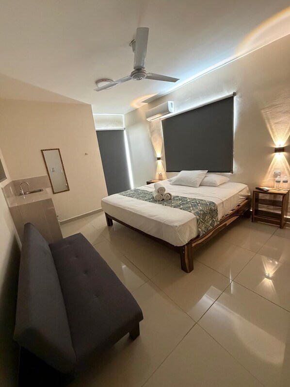 Ein modernes Schlafzimmer mit Bett, Nachttisch, Lampe und Deckenventilator.