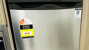 A stainless steel dishwasher with an energy efficiency rating sticker, a QR code, and a control panel with a brand logo. - Modern Studio Sydney (108) - 2 km to Sydney University (Stanmore)