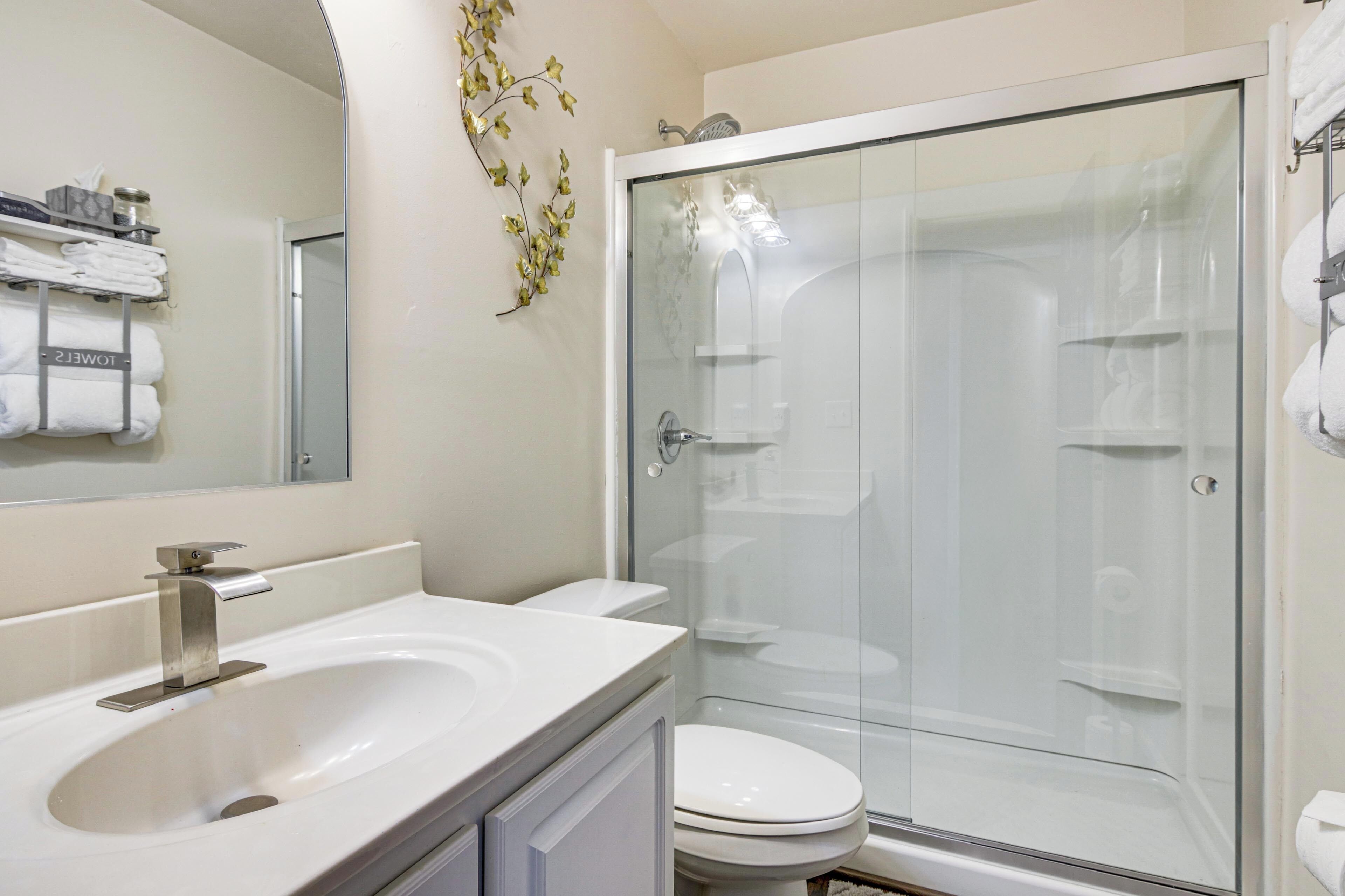 A bathroom with a sink, toilet, and glass-enclosed shower.