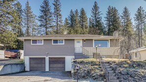 A two-story house with a garage, a front porch, and a staircase leading to the second floor. - Nurse-friendly Spokane Home Near Medical Centers (Spokane)