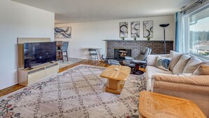 A living room with a TV, sofa, fireplace, and artwork on the wall. - Nurse-friendly Spokane Home Near Medical Centers (Spokane)