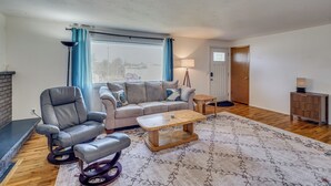 A living room with a sofa, armchair, coffee table, and a rug. - Nurse-friendly Spokane Home Near Medical Centers (Spokane)