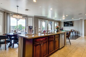 A spacious kitchen with a large island, built-in appliances, and a dining area with a pool table. - Swim-up Bar & Games! Ultimate Goodyear Group Stay (Goodyear)