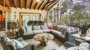 A spacious patio with wicker furniture, a glass coffee table, and a ceiling fan. - Private Pool & Dock: Riverfront 'bridge Escape' (North Fort Myers)