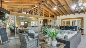 A spacious interior with high ceilings, wicker furniture, and a dining area. - Private Pool & Dock: Riverfront 'bridge Escape' (North Fort Myers)