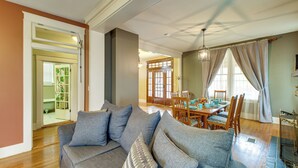 Una sala de estar con sofá, mesa de comedor, sillas y chimenea.